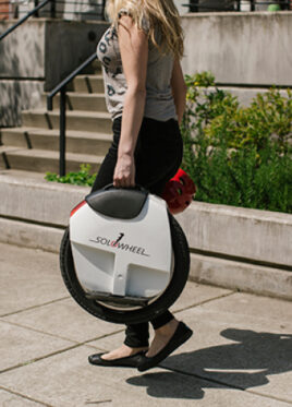 Young adult carrying a Solowheel