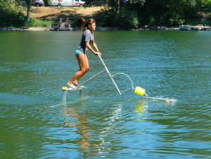 A young adult using an AquaSkipper in a lake